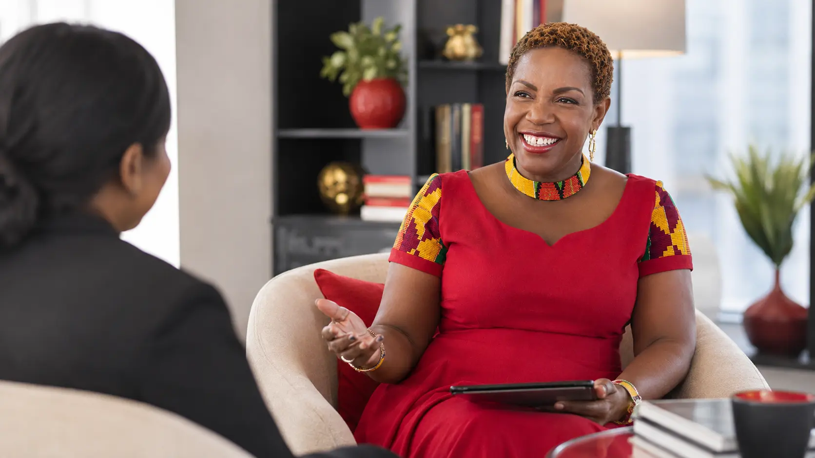 Lily Naadu Mensah in a one-to-one coaching conversation, taking notes