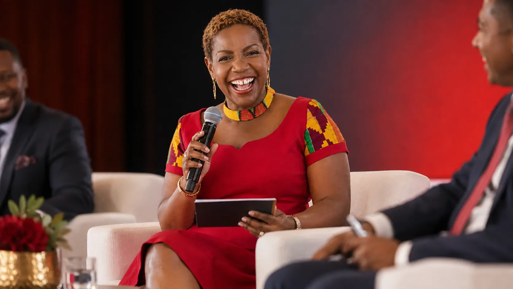 Lily Naadu Mensah moderating a panel discussion on stage with a microphone